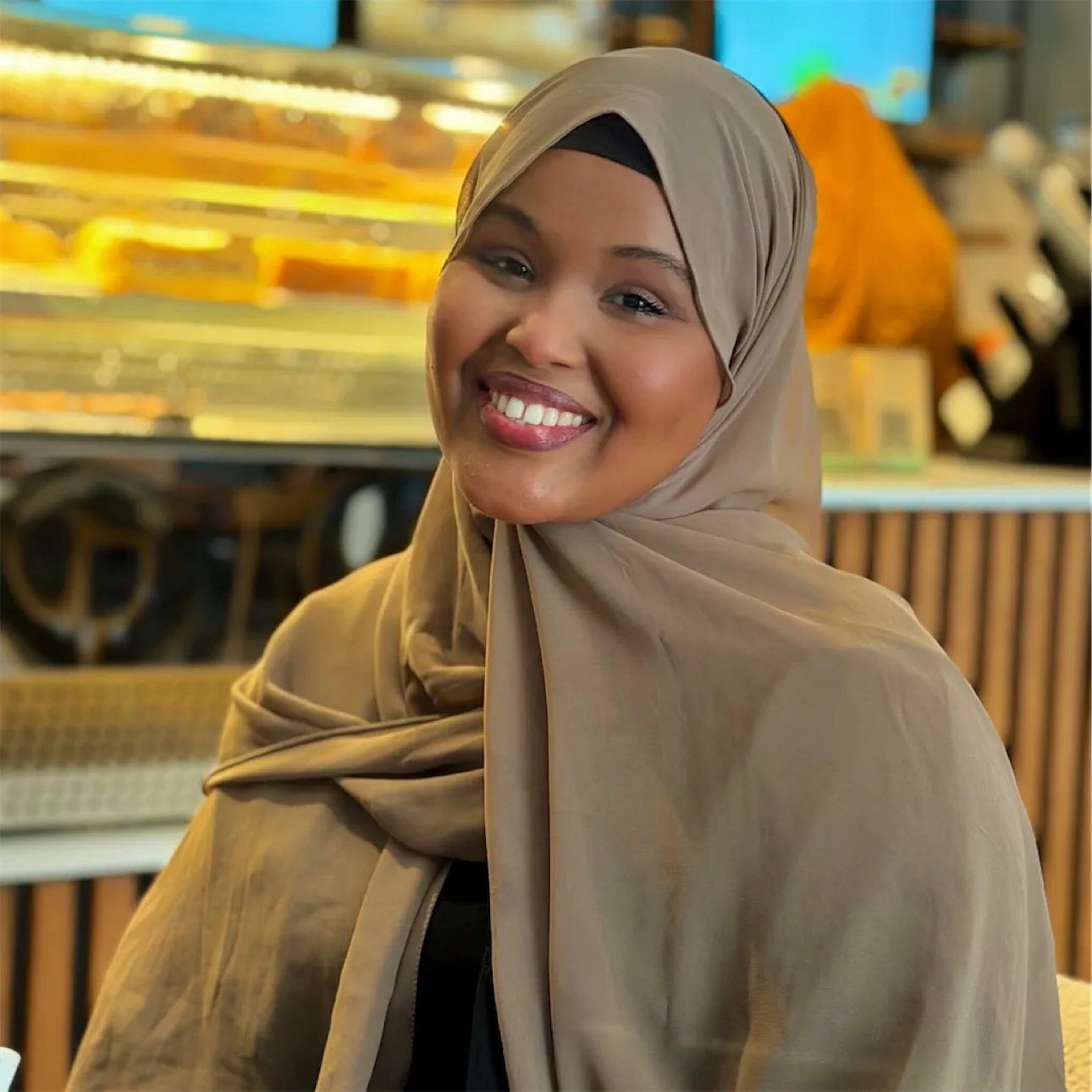 Her smiling across a café table