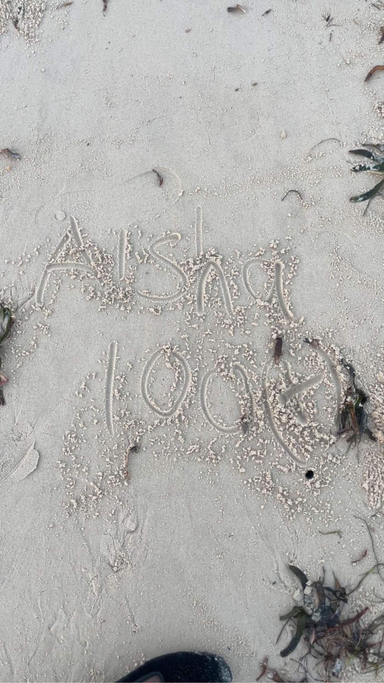 Names and a date traced into sand