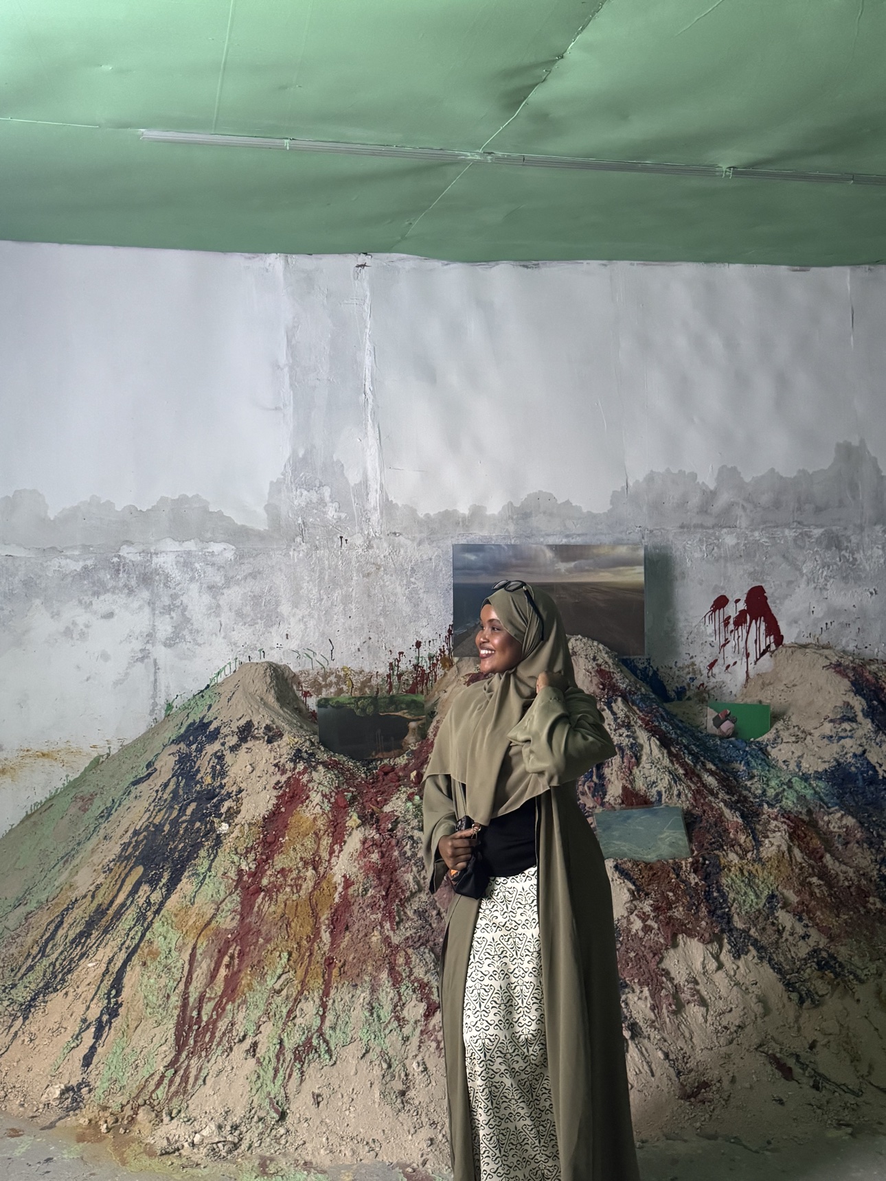 Her standing before a painted wall