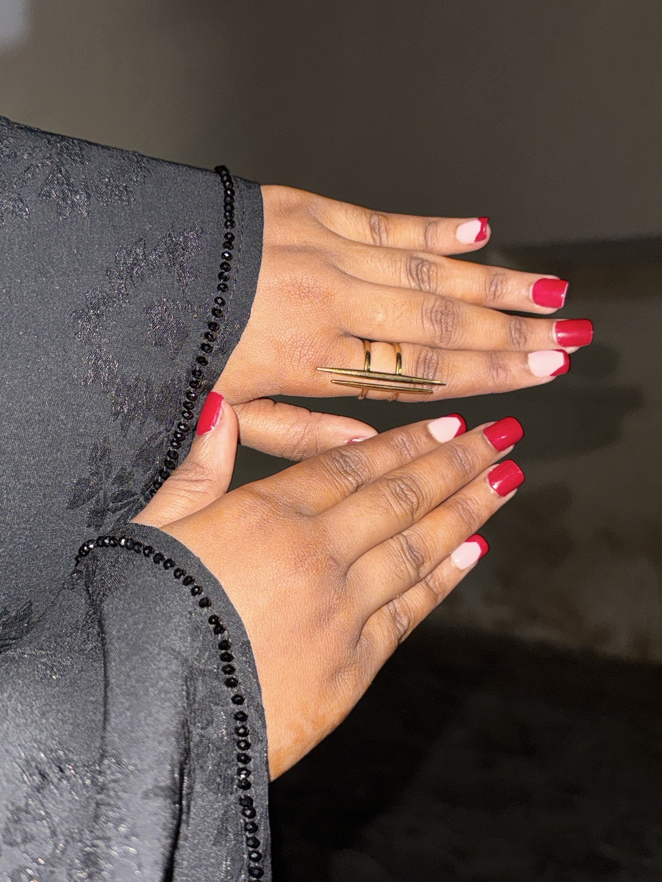 Her hands with red nails and gold rings