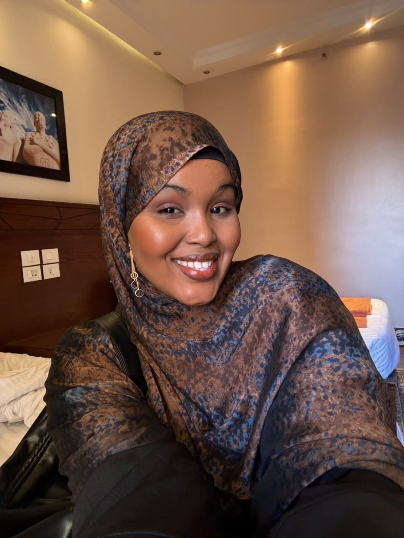 Her smiling indoors in a patterned hijab